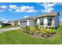 Attractive single-story home with lush landscaping, a well-manicured lawn, and a driveway at 1972 Spring Shower Cir, Kissimmee, FL 34744