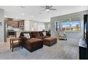 Inviting open-concept living room featuring wood-look floors, a ceiling fan, and large windows at 1972 Spring Shower Cir, Kissimmee, FL 34744