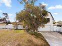 Charming home featuring white siding, an attached two-car garage, and a well-maintained front yard with mature trees at 2531 Ludlow St, Deltona, FL 32738