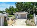 Detached one car garage with gray siding and a brick lined path to the back yard at 265 W Constance Rd, Debary, FL 32713