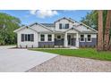 New construction home featuring white wood facade, black shutters, and a concrete driveway at 2650 Howard Ave, Oviedo, FL 32765