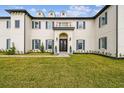Elegant home featuring a manicured lawn, symmetrical landscaping, and classic architectural details at 30215 Island Club Dr, Deer Island, FL 32778