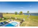 Expansive backyard featuring a pool, waterfront view, and direct access to a lake and boat dock at 30215 Island Club Dr, Tavares, FL 32778