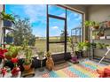 A screened lanai filled with plants overlooks a sprawling green yard with distant trees at 3632 Solana Cir # B, Clermont, FL 34711