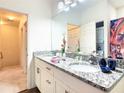Well-lit bathroom boasts a double vanity with granite countertops and modern fixtures at 5352 Diplomat Ct # 107, Kissimmee, FL 34746