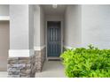 Welcoming front door, flanked by stone accents and lush greenery, inviting you into your dream home at 580 Buchannan Dr, Davenport, FL 33837