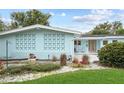 A cozy light blue home showcasing a welcoming front porch with white chairs and mid-century modern decorative elements at 625 Worthington Dr, Winter Park, FL 32789