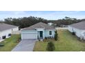 Aerial view of a single-Gathering home with solar panels, a brick paved driveway, and a manicured lawn at 663 Fairview Ave, Haines City, FL 33844