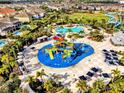 Overhead view showcases the water park and pool amenities within the community, surrounded by lush landscaping and homes at 7419 Marker Ave, Kissimmee, FL 34747