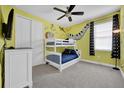 A playful bedroom with a bunk bed, cartoon artwork, and a ceiling fan at 7419 Marker Ave, Kissimmee, FL 34747