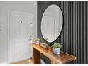 Stylish entryway featuring a wooden console table with decor and an oval mirror at 8990 Cuban Palm Rd, Kissimmee, FL 34747