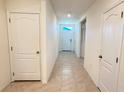 Open hallway with tile floor, white doors and trim and natural light at 1003 Cascade Dr, Davenport, FL 33837