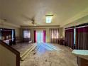 Spacious living room with a ceiling fan, curtains, and tile flooring, bathed in natural light from the sliding glass door at 11290 Se 189Th Ct, Ocklawaha, FL 32179