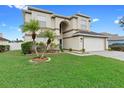 Attractive two-story home with palm trees, a well-kept lawn, and a convenient two-car garage at 12543 Waterhaven Cir, Orlando, FL 32828