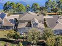Aerial view showcases a house with a screened pool overlooking a tranquil lake at 16310 Rock Coast Dr, Winter Garden, FL 34787