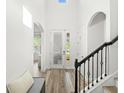 Bright foyer featuring wood floors, staircase with black iron spindles and lots of natural light at 16310 Rock Coast Dr, Winter Garden, FL 34787