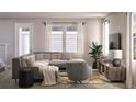 Inviting living room featuring a comfortable gray sectional, neutral tones, and a large window at 167 Aulin Ave, Oviedo, FL 32765