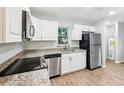 Updated kitchen boasts white cabinets, stainless steel appliances, and granite countertops for a modern feel at 1834 Willie Mays Pkwy, Orlando, FL 32811