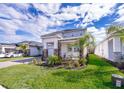 Beautiful home's landscaped front yard and brick driveway lead up to a covered entrance at 187 Aces High Ln, Davenport, FL 33896
