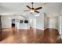 Spacious living room with hardwood floors, ceiling fan, vaulted ceiling, and access to the kitchen at 25 Maple Crse, Ocklawaha, FL 32179