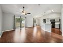 Bright living room with hardwood floors, ceiling fan, vaulted ceiling, and access to the kitchen at 25 Maple Crse, Ocklawaha, FL 32179