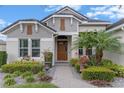 Welcoming front entrance featuring a brick walkway, lush landscaping, and beautiful flower accents at 31746 Red Tail Blvd, Sorrento, FL 32776