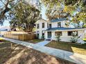 Two-story home with architectural detail, inviting entryway, and mature landscaping at 428 E Orange Ave, Eustis, FL 32726