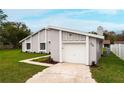 Attached garage with updated landscaping and freshly painted gray facade at 820 E Flag Ln, Kissimmee, FL 34759