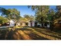 Charming single-Gathering home with a well-manicured lawn, mature trees, and a pink front door at 109 Crestwood Dr, Longwood, FL 32779