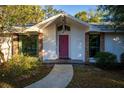 A beautiful, modern home entrance featuring a vibrant pink door and decorative brick accents at 109 Crestwood Dr, Longwood, FL 32779