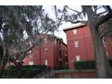 Exterior view of a red brick apartment building with lush greenery and mature trees surrounding it at 122 Vista Verdi Cir # 216, Lake Mary, FL 32746