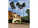 Entrance to Villanova community with lush tropical landscaping and orange residential building at 12204 Wild Iris Way # 109, Orlando, FL 32837