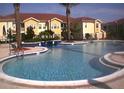 Large, inviting community pool with in-water seating and nearby apartment buildings at 12204 Wild Iris Way # 109, Orlando, FL 32837