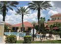 View of the community pool with lounge chairs and a clubhouse in the background at 12204 Wild Iris Way # 109, Orlando, FL 32837