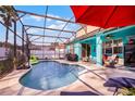 Inviting screened pool area featuring an umbrella, lounge chairs, and space for entertaining at 1602 Pine Ridge Dr, Davenport, FL 33896