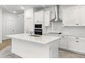 Modern kitchen featuring white cabinets, stainless steel appliances, and a center island with a sink at 1988 Sunshine Peak Dr, Minneola, FL 34715