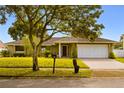 Inviting single-story home featuring a lush green lawn and a classic front entrance at 211 S Deerwood Ave, Orlando, FL 32825