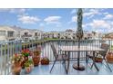 Relaxing balcony view with table and chairs overlooking waterfront and buildings against a blue sky at 2552 Woodgate Blvd # 204, Orlando, FL 32822