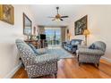 Comfortable living room showcasing plush seating, wood floors, ceiling fan, and a serene outdoor view at 2552 Woodgate Blvd # 204, Orlando, FL 32822