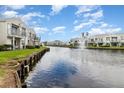 Scenic waterfront view of townhouses along a tranquil canal with a fountain and lush landscaping at 2552 Woodgate Blvd # 204, Orlando, FL 32822