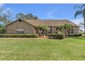 Charming brick home featuring manicured lawn and tasteful landscaping, creating a welcoming curb appeal at 2825 Lake Tohopekaliga Blvd, Kissimmee, FL 34746