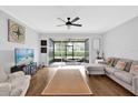 Relaxing living room featuring hardwood floors, modern furniture, a ceiling fan and access to a screened patio with a hammock at 2851 Polvadero Ln # 107, Orlando, FL 32835