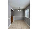 Open dining area with neutral walls, tile floors and a modern chandelier for a touch of elegance at 4154 Pinebark Ave # 3, Orlando, FL 32811