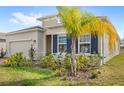 A view of the home's facade, with neat landscaping and blue shutters providing a pop of color at 5593 Vigo Loop, St Cloud, FL 34771