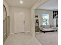 Inviting entryway with tile flooring, a white front door and a view into the adjacent living space at 5663 Keaton Springs Dr, Lakeland, FL 33811