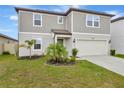 Inviting two-story home with a manicured lawn, featuring a covered entryway and attached two-car garage at 5663 Keaton Springs Dr, Lakeland, FL 33811