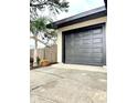 Exterior of the garage, featuring a new gray door, black trim, and landscaping at 722 Eagle Ave, Longwood, FL 32750