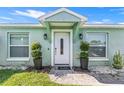 Charming home featuring a white front door with decorative plants and a well-manicured lawn at 905 Bella Vista Way, Orlando, FL 32825