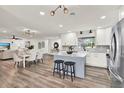 Open-concept kitchen with a center island, granite countertops, white cabinets, and modern stainless steel appliances at 921 W Lake Brantley Rd, Altamonte Springs, FL 32714