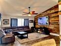 Cozy living room with a decorative wood accent wall, modern ceiling fan, and comfortable leather sectional at 1002 Royalton Rd, Orlando, FL 32825